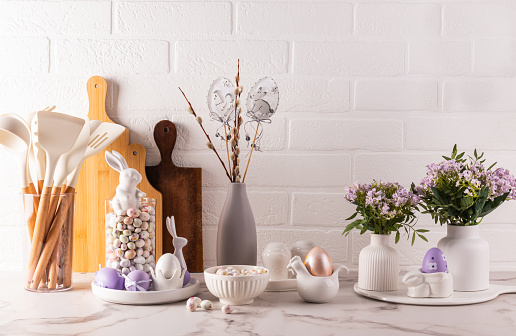 Eco-friendly kitchen utensils, wooden cutting boards, vase with willow twigs, Easter decorations. Eco style. Front view. brick wall