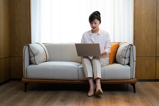 Woman sitting on sofa using a computer