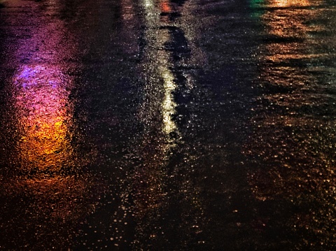The light on the road is wet because after the rain.