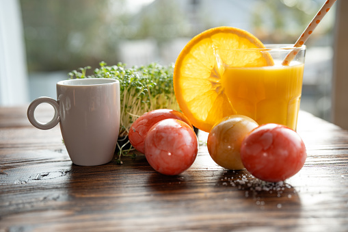 Healthy easter snack with natural ingredients and freshly squeezed orange juice and espresso on wooden table.