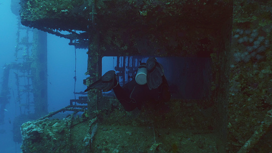 Scuba diver swim down corridor of ferry Salem Express shipwreck, Red sea, Safaga, Egypt