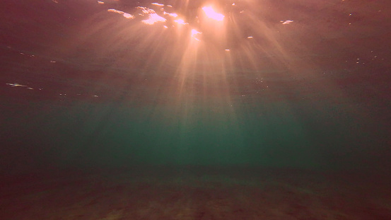 Low angle wide shot sun rays penetrating surface of water in the morning time, Underwater light creates beautiful veil, consisting of sunlight in the morning time, Red sea, Egypt