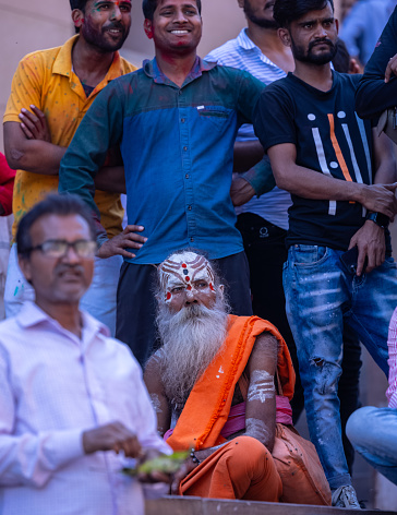 Varanasi, Uttar Pradesh, India - March 2023: Masan holi, unidentified sadhu baba sitting at manikarnika ghat during masan holi festival.