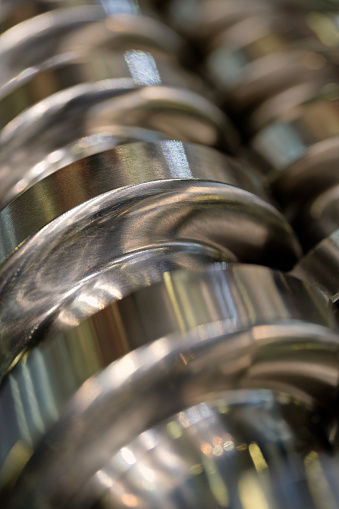 Steel helical conveyer screw, close-up shot, selective focus, abstract industrial background
