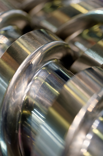 Steel helical conveyer screw, close-up shot, selective focus, abstract industrial background