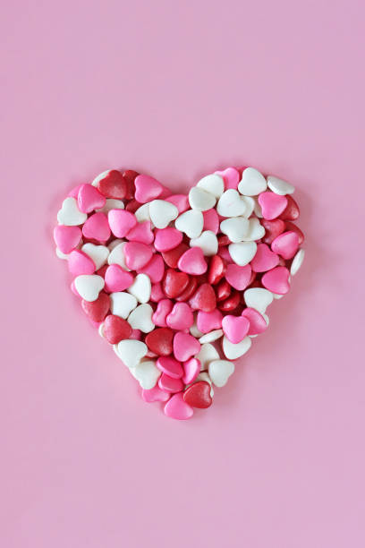 istock Image of heart shape created from red, pink and white candy hearts, Valentine's day decorations, mottled pink background, elevated view, Valentine's Day and romance concept, copy space 1972636385