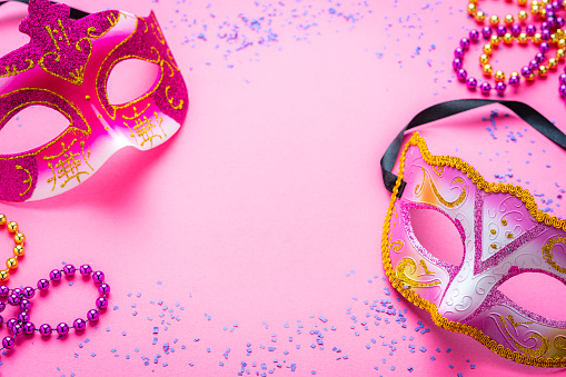 Two pink Mardi Gras masks on pink background. Copy space. High resolution 42Mp studio digital capture taken with Sony A7rII and Sony FE 90mm f2.8 macro G OSS lens
