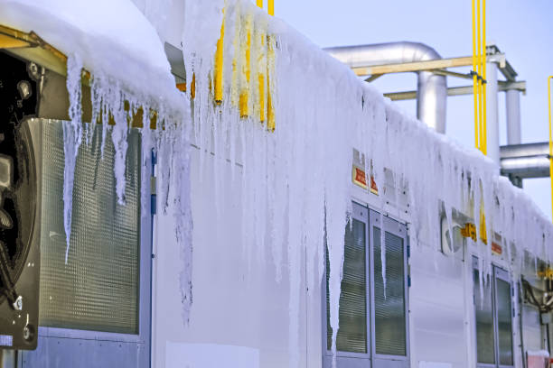 duże sople lodu zwisają z dachu zakładu produkcyjnego. koncepcja bezpieczeństwa. - melting ice icicle leaking zdjęcia i obrazy z banku zdjęć