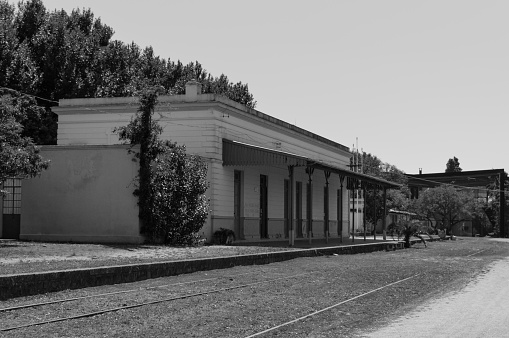 wide black and white view of the port of Sanremo in summer. A Vespa is parked and behind there are the boats