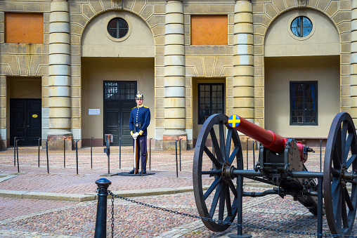 Stockholm, Sweden - July 15, 2023: Old Cannon and Soldier of the Swedish Royal Guard near the Royal Palace. Capital of Sweden with beautiful old buildings and architecture