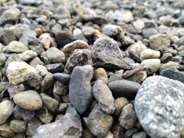Mound of granite gravel, stones, crushed stone close-up. Rough seamless texture, construction material background.