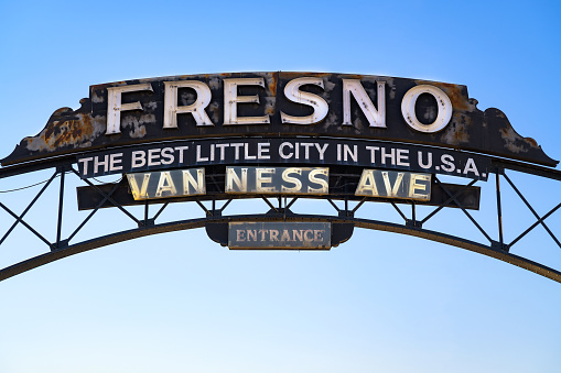 Fresno, California, USA - June 17, 2023 : Rustic archway sign reading 'Fresno - The Best Little City in the U.S.A.' over Van Ness Avenue.