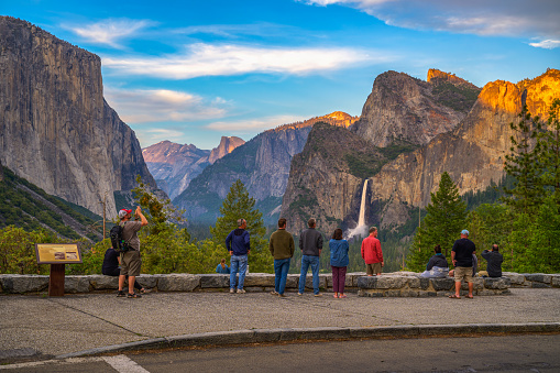Yosemite Valley, California, USA - June 16, 2023 : Tourists at Tunnel View overlook enjoying the scenic Yosemite Valley and Bridalveil Waterfall.