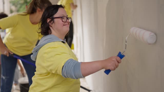 Volunteers painting wall together