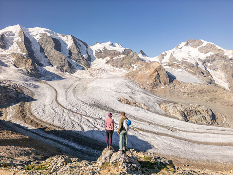 Couple mountaineers stand on top of glacier, conquering adversity