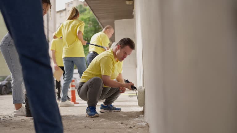 Volunteers painting wall outdoors