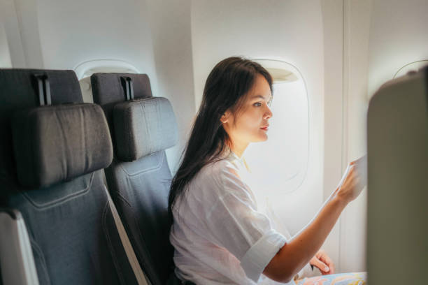 istock young woman on airplane using on board entertainment 1972748284
