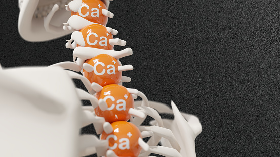 A skeleton with calcium balls stacked on top of it. The calcium balls represent the importance of calcium for strong bones. 3d render.
