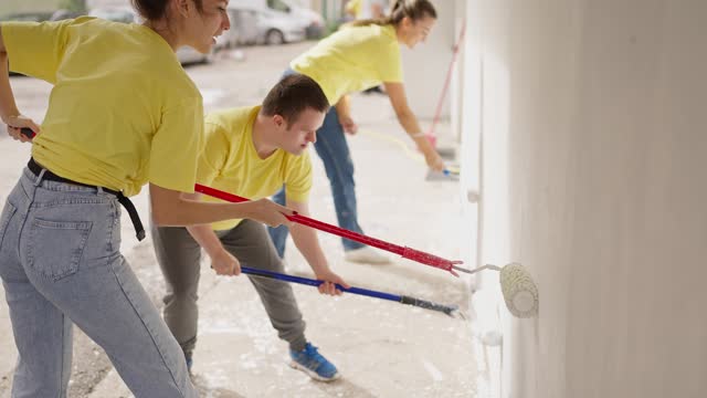 Volunteers painting building wall