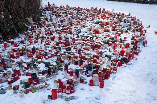 A lot of memorial candles in the snow on a day of mourning in memory of a tragedy.