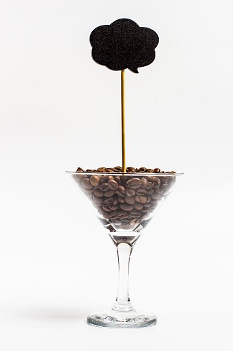 Coffee beans in a martini glass on a white background