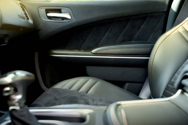 istock black interior of a modern car. Dashboard. Luxury leather steering wheel. Auto controls. Car doors inside. Car chairs and seats. Car sofa. Back and front row. Interior and door trim. High quality 1972799392