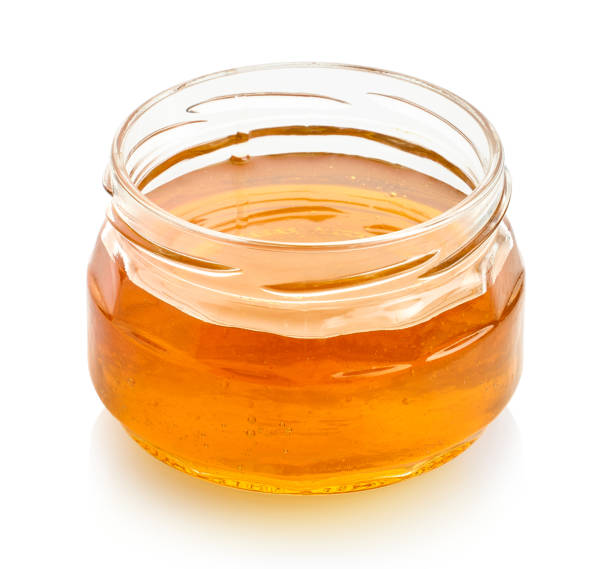 istock Glass jar full of honey on white background 1972801027