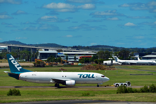 Brisbane, Queensland, Australia: Toll Aviation 737-484(SF) (registration ZK-TLL MSN 25362) being towed along a taxiway- Brisbane Airport (BNE). Toll Aviation is an Australian cargo airline headquartered in Brisbane, founded as Jetcraft Aviation in 1989, in 2007 , it filed for bankruptcy and was later acquired by the Toll Group, an Australian logistics conglomerate.