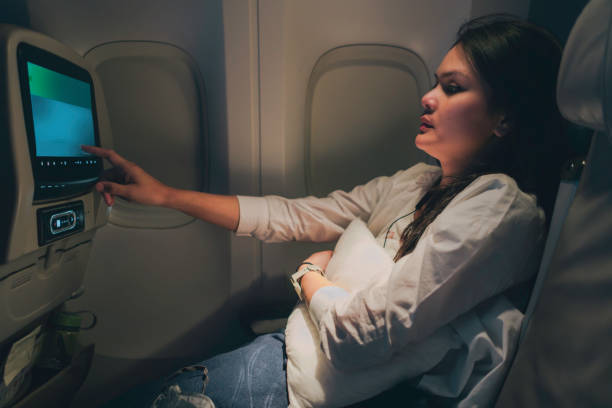 istock young woman on airplane using on board entertainment 1972820915