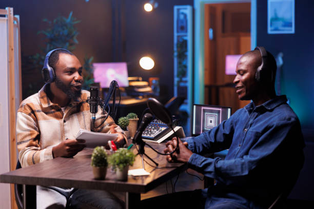 istock Podcaster chats with guest in home studio 1972834671