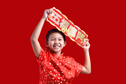 Happy Chinese new year. Happy asia wearing traditional cheongsam qipao dress with gesture of congratulation isolated on red background presentation for Chinese new year festival.