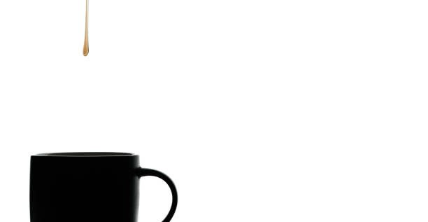 Minimalist image of drop of honey falling into a mug. It is a studio shot with white background. Healthy and natural nutrition concept.