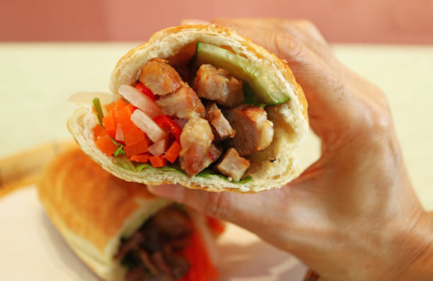 Closeup of Hand Holding Mouthwatering Vietnamese Sandwich Banh Mi