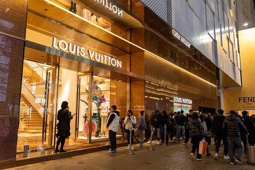 Hong Kong - January 27, 2024 : Shoppers queue outside the Louis Vuitton store in Tsim Sha Tsui, Kowloon, Hong Kong.