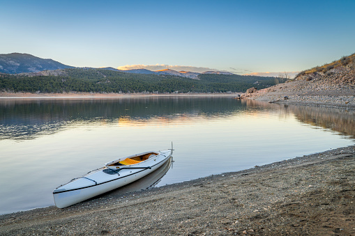 expedition canoe on a shore of Carter Lake in northern Colorado, warm winter afternoon