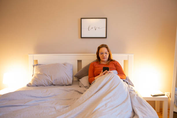 istock Woman using phone in bed 1972877865