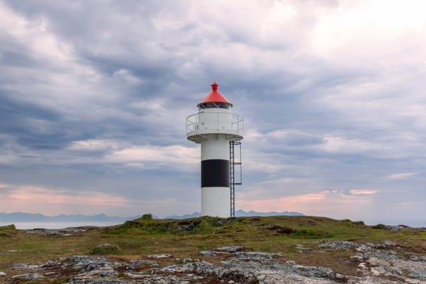 istock The Borhella Lighthouse stands stark against a dramatic sky, its red cap a stark contrast to the moody clouds above the Norwegian coastline 1972905572
