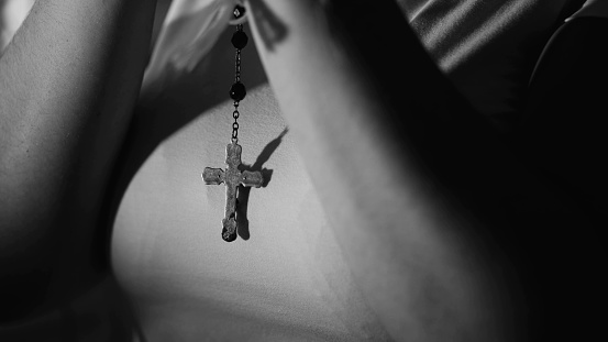 Close-Up of Catholic Cross and Rosary in Prayer Symbolizing Hope and Faith in Religious Spirituality in Black and White monochrome