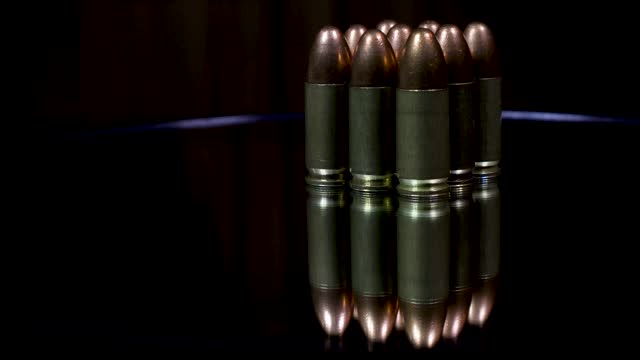 A stack of 9mm bullets with reflection on the glass plate of the rotating table.
