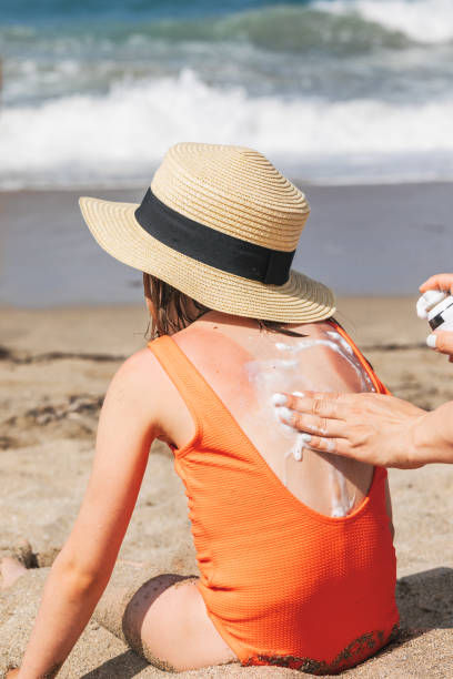 istock Mother applying sunburnt  relief spray to her child at a beach 1972995383