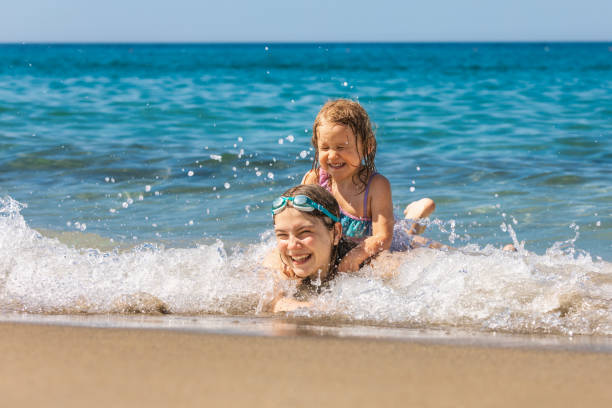 istock Joyful children playing in the shallow beach waves 1972998265