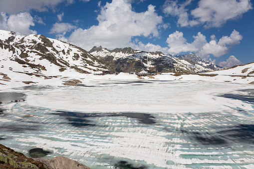 Totesee or Totensee at Grimsel Pass with melting snow at the first day open after winter. The Grimsel Pass is a mountain pass in Switzerland
