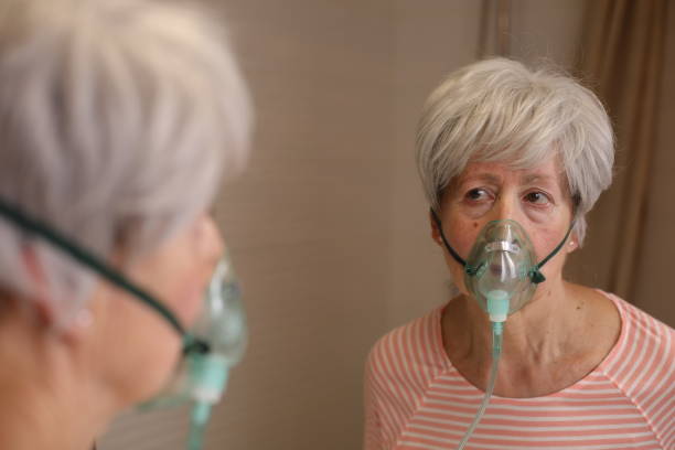 istock Senior woman using a breathing aid 1973005634