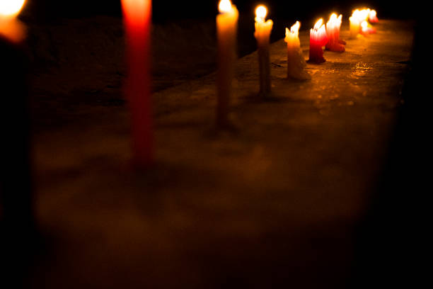 Tea light candles burning in the the church. Candles softly illuminate the sacred space. Warm ambiance