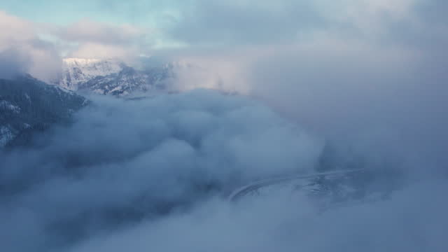 Mountain Highway in Winter Snow and Fog Clouds Aerial