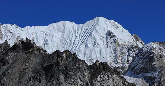 Blue sky over a high white mountain in the Himalayas, view from Gorakshep, Nepal.