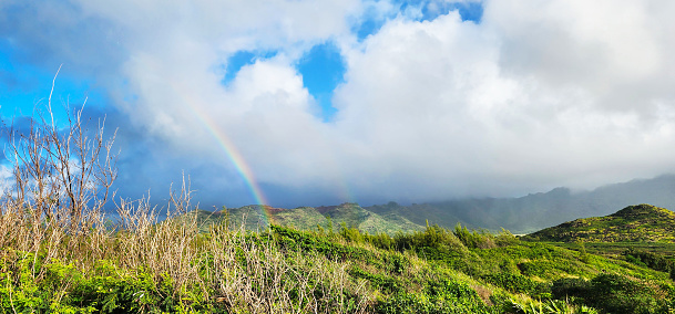 Beautiful photo of double rainbow over the lush mountains of Kauai, Hawaii.