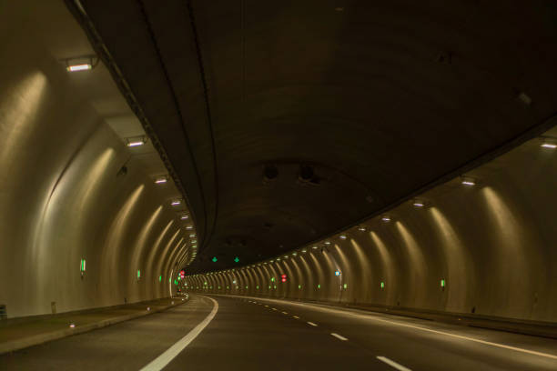 istock Underground city road tunnel, curve night illuminated freeway 1973068769