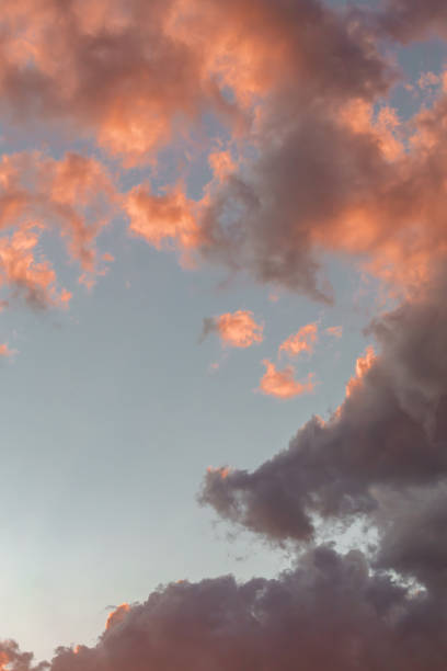 istock Dramatic cumulus clouds on sunny day at sunset painted in purple with sun. Atmosphere multicolor vertical background or wallpaper 1973069176