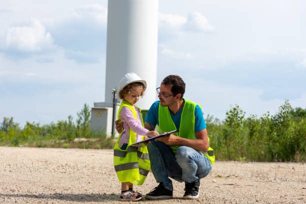 istock Father with daughter on construction site in green vests 1973069280